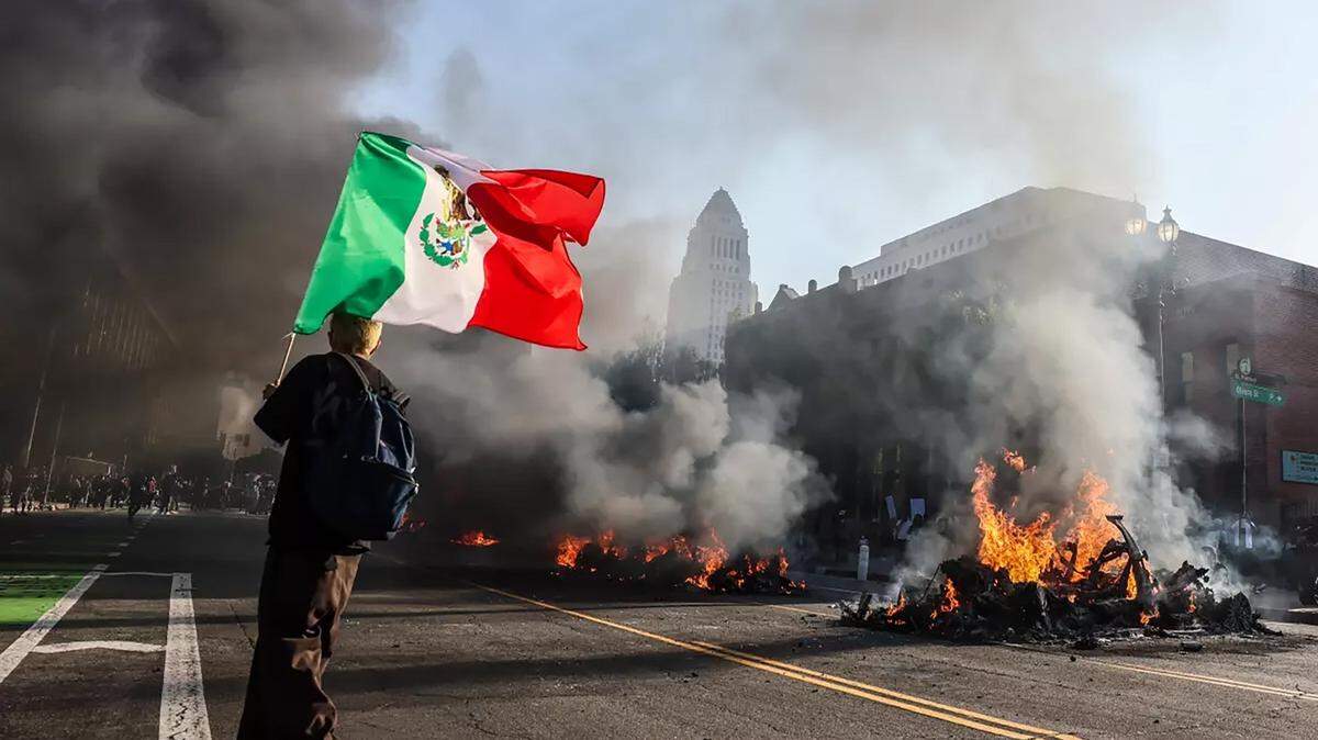 Cars burn on a Los Angeles street near City Hall after thousands of protesters take to the streets to protest ICE immigration raids throughout the city, on June 8, 2025. (Robert Gauthier/Los Angeles Times/TNS)