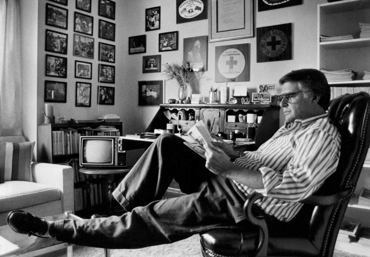 KCRA anchor Stan Atkinson reads at his apartment in 1986, surrounded by memorabilia of his career and wide-ranging travels.