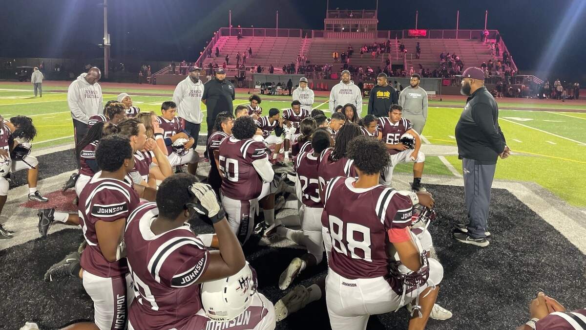 The Hiram Johnson High School football team kneels at midfield following a 47-0 victory over Florin on Friday, Oct. 20, 2023.