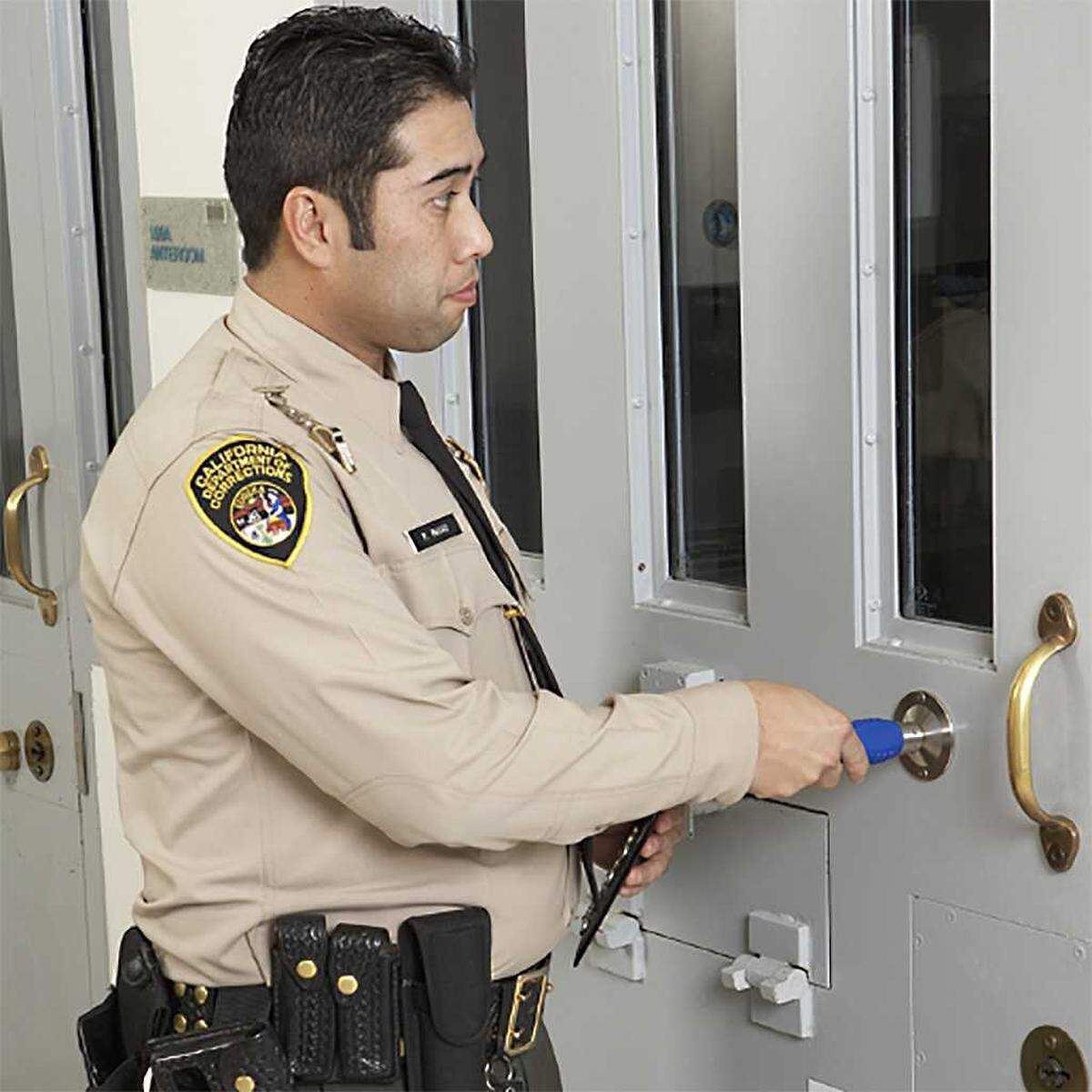 An image used for promotional purposes on the Guard1 website illustrates a California correctional officer using the Guard1 Pipe II monitoring device.