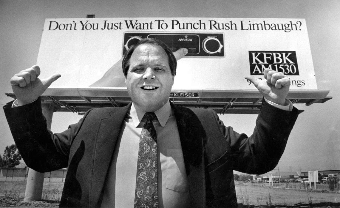 Rush Limbaugh, a KFBK AM morning radio personality before he became a national media presence, gestures in 1986, to a Sacramento billboard promoting his local talk radio show that was already reflecting the divisive conservatism he would later take nationwide.