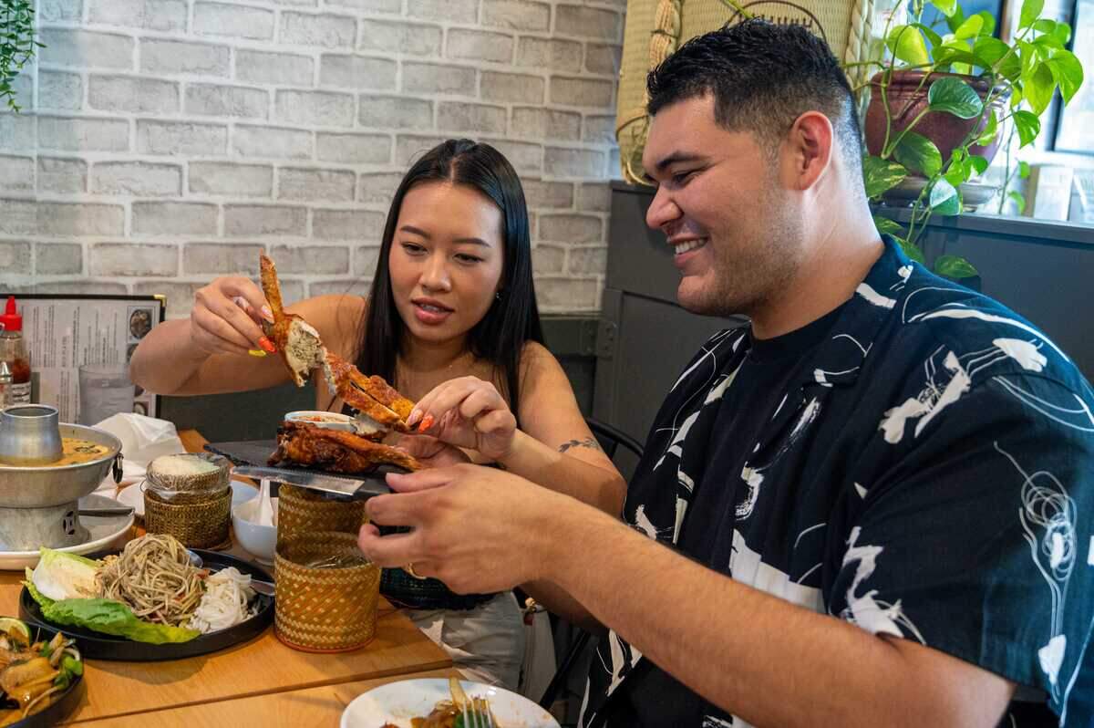 Ellie Andrade separates a stuffed chicken wing while Lupe Andrade holds the plate at Vientiane Restaurant in West Sacramento on July 15.