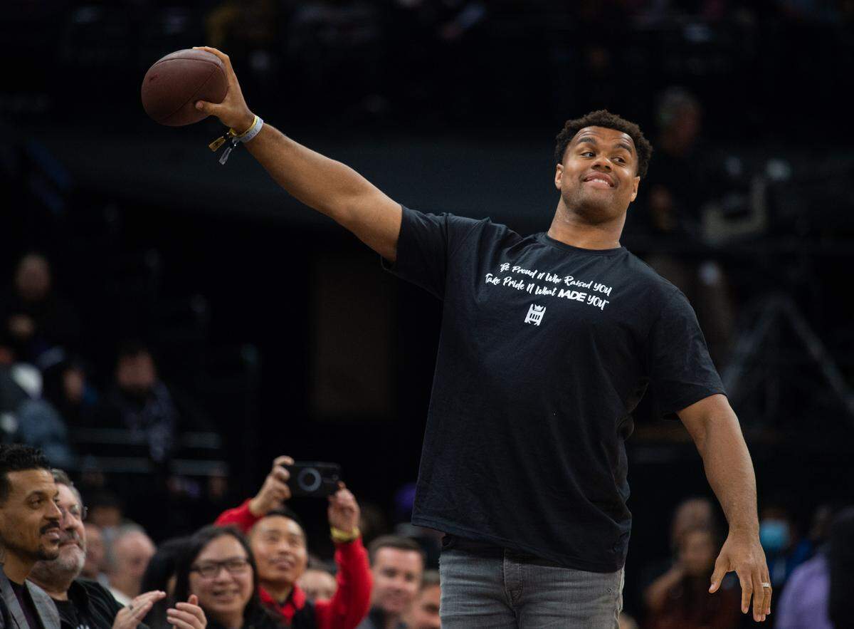 NFL star Arik Armstead prepares to throw an autographed ball to fans during a Sacramento KIngs game at Golden 1 Center in 2022.