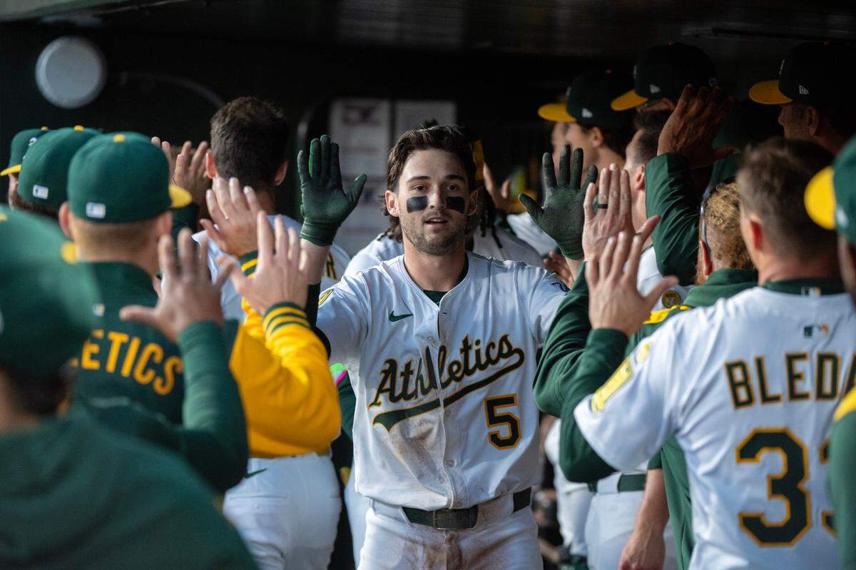 The Athletics Jacob Wilson (5) is greeted in the dugout after scoring on a Gio Urshela hit in the bottom of the first inning in a Major League Baseball game against the San Diego Padres on Tuesday, April 8, 2025 at Sutter Health Park in West Sacramento.