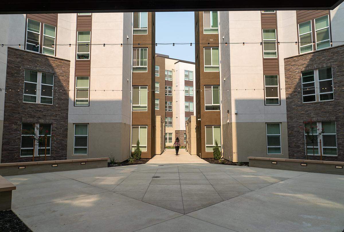 The Crossings’ general manager Lisa Corey walks between buildings at The Crossings on Tuesday, August 21, 2018 in Sacramento, Calif. The Crossings is one of 7 new housing developments being built around Sacramento State as developers plan to build housing for 4,000 Sacramento State University students.