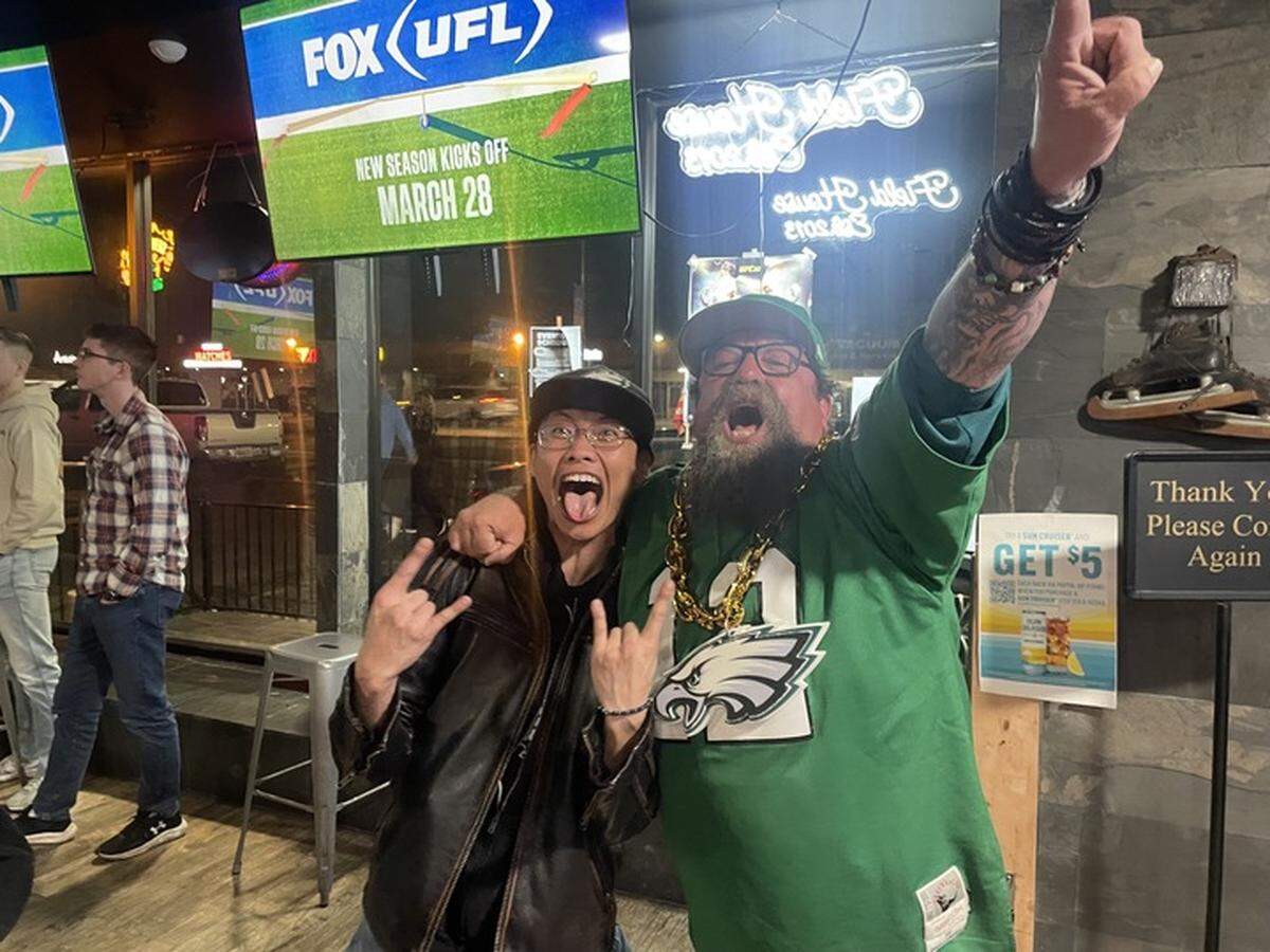 Philadelphia Eagles fans Tong Vue, left, and Bruce Fox enjoy their team’s victory in Super Bowl LIX on Sunday at Field House bar in Arden Arcade. The bar is a haven for Chiefs fans but frequent patrons say fans from other teams often come to enjoy the game.