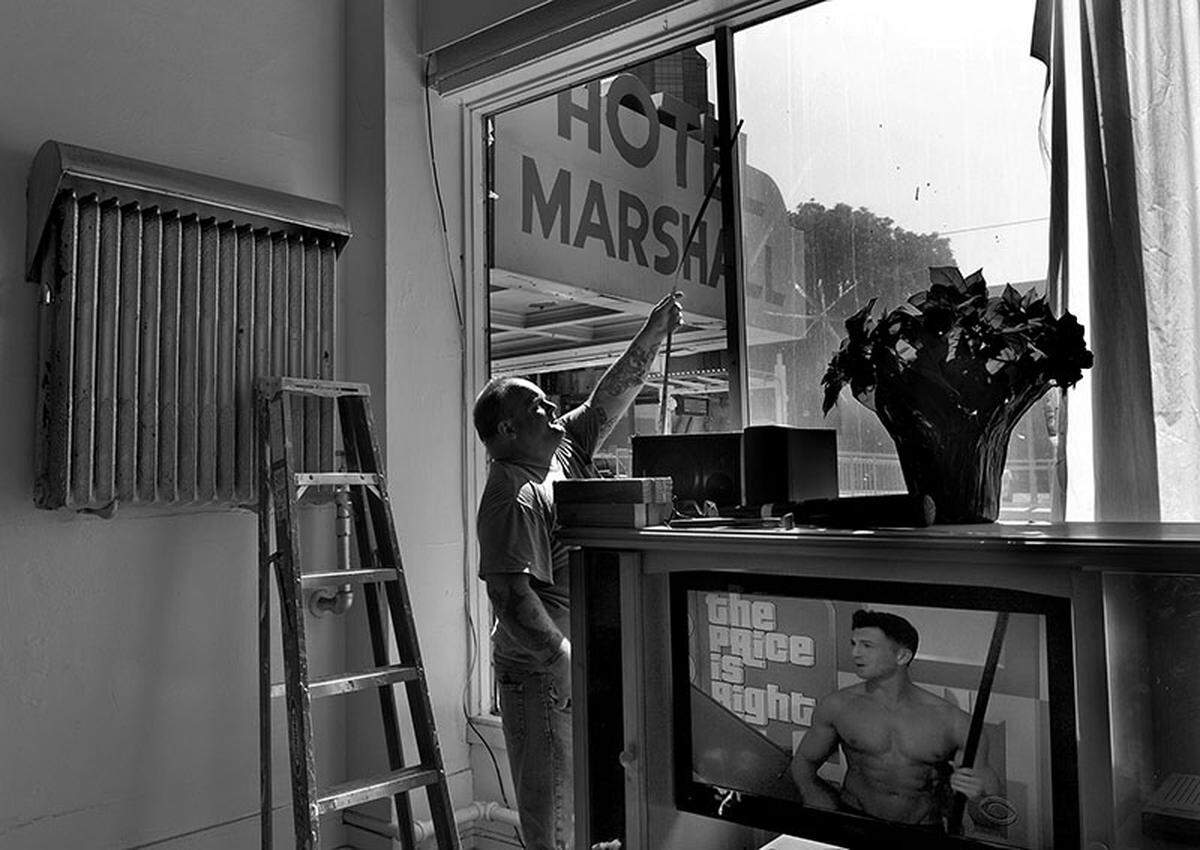 Paul Jonelous, a maintenance worker, prepares to board up a shattered window after the Marshall’s closure. Fifty-seven longtime residents were given help finding new homes after a developer announced plans to transform the hotel into a luxury property.