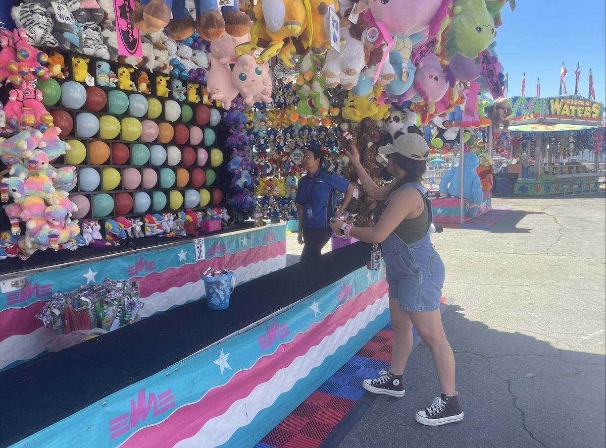 A Sac Bee reporter plays a carnival game at the California State Fair.