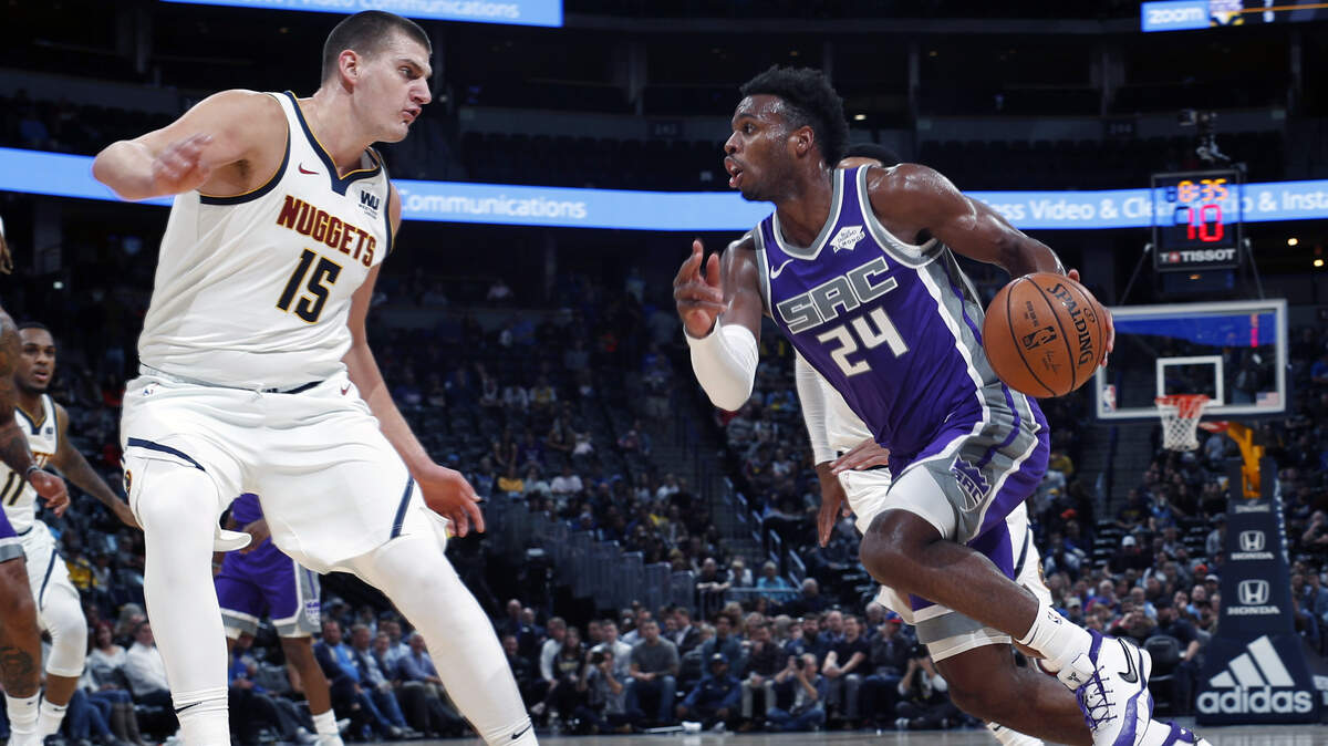 Kings guard Buddy Hield, right, drives against Denver Nuggets center Nikola Jokic on Tuesday in Denver.