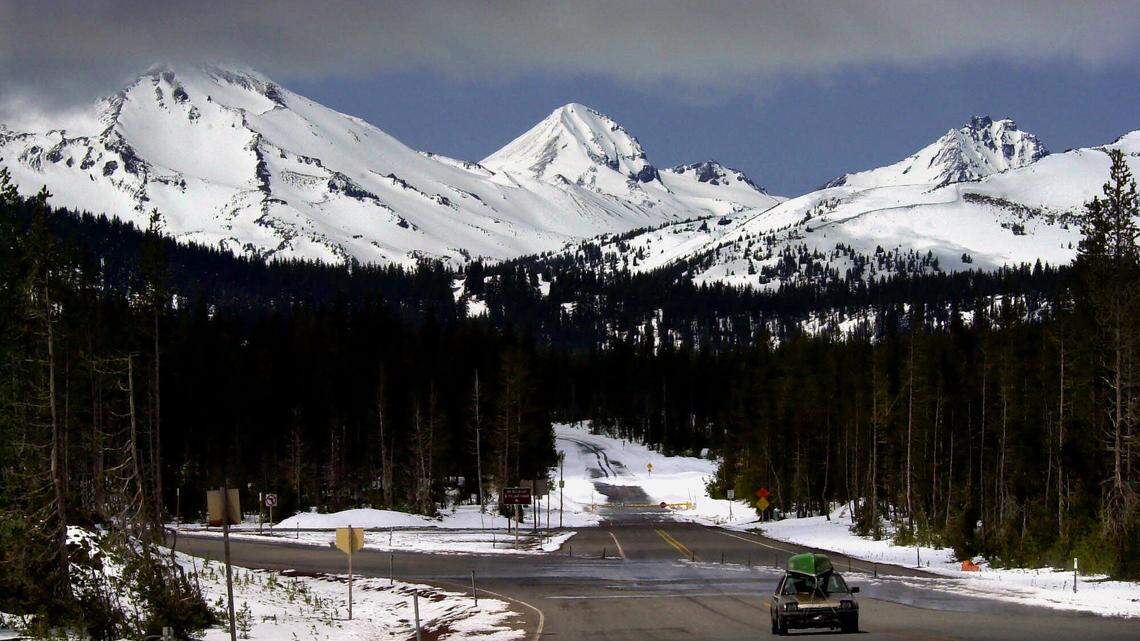 File--In the May 16, 2001 file photo, a car travels down the Cascade Lakes Scenic Byway with the Three Sisters mountains in the background 25 miles west of Bend, Ore. A proposal to film a Mercedes-Benz commercial on the Byway in the Deschutes National Forest has collapsed with a location scout saying the U.S. Forest Service dragged its heels and the agency saying the scout turned in skimpy paperwork. (AP Photo/Don Ryan, file)