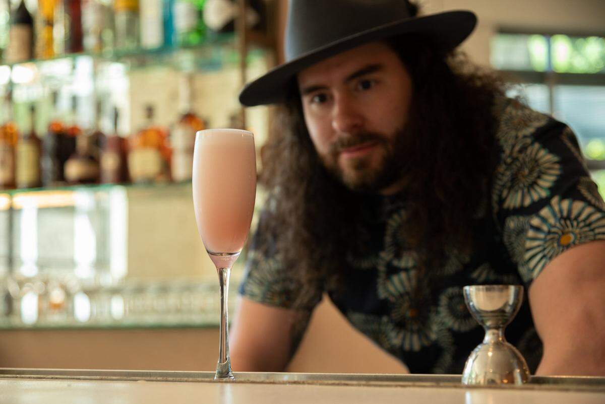 Bartender Alex Walker makes a Rose Rouge cocktail made with gin, pomegranate and bubbles at Juju Kitchen & Cocktails in Sacramento on Thursday. Juju Kitchen & Cocktails is David English’s new small plates and drinks spot in downtown Sacramento.