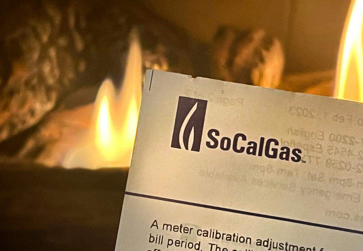 A&nbsp;gas fireplace illuminates a SoCalGas bill. 