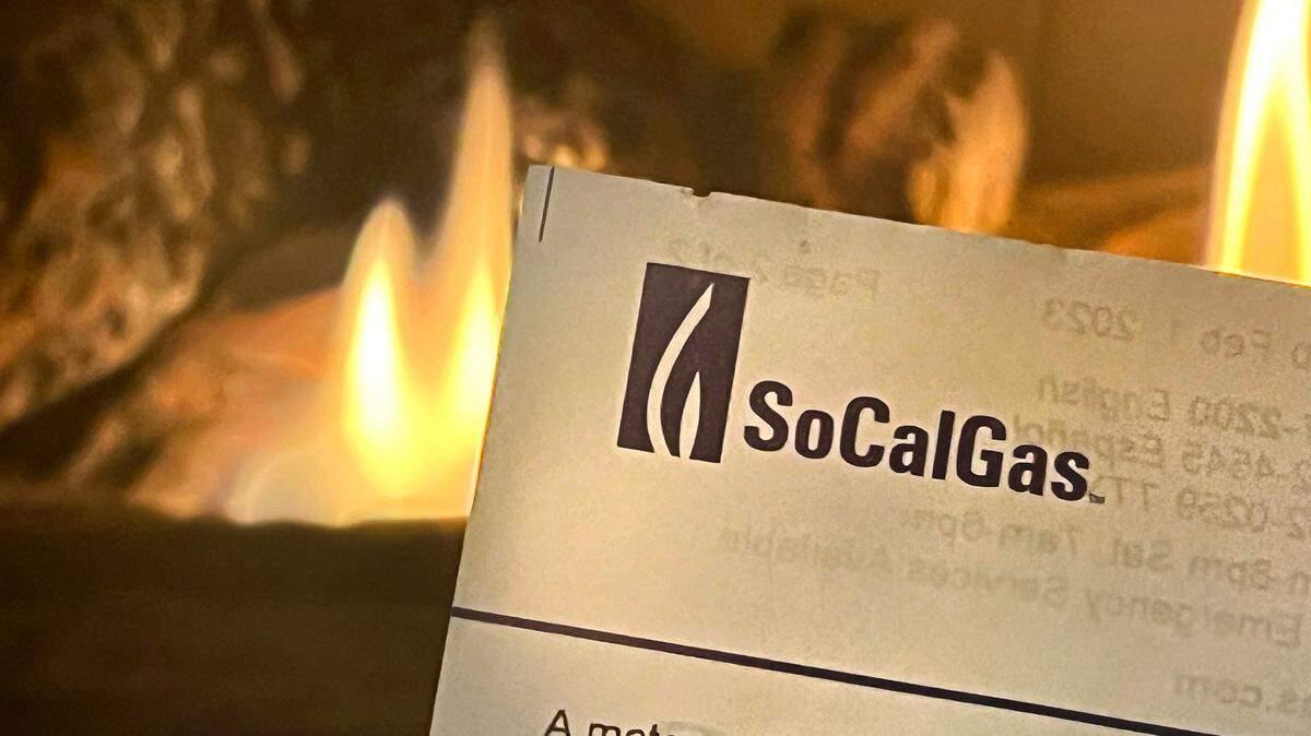 A gas fireplace illuminates a SoCalGas bill. 

