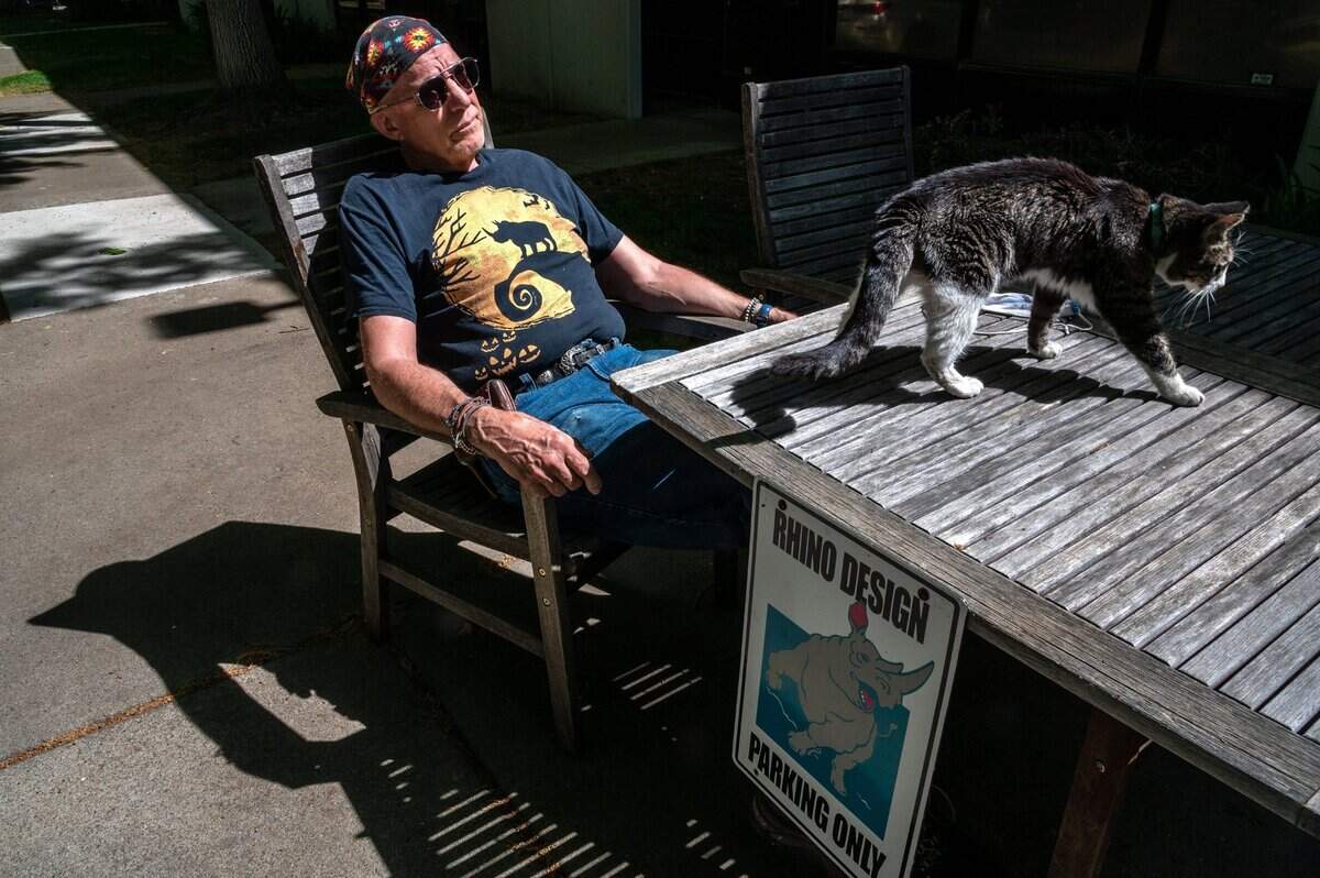 Louis Warfield, 70, talks about the homeless city on wheels on Lathrop Way and the impact it has had on his business, Rhino Design, while sitting next to his cat Mittens in April. He says at one point, there were over a hundred vehicles, campers and tents there. “It got worse with COVID and that’s understandable,” he said. “We call the cops and they come out and they can’t do anything.”