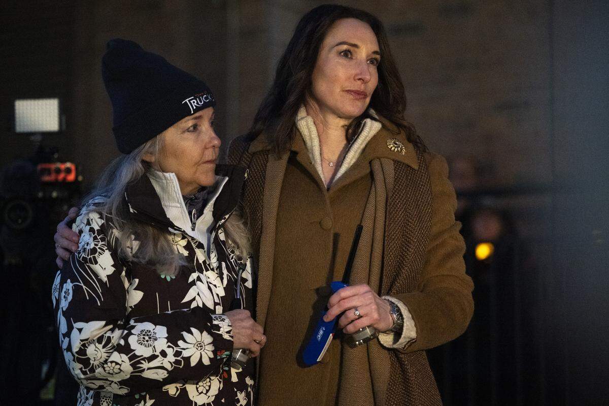 Truckee Vice Mayor Courtney Henderson, right, and Mayor Anna Klovstad listen to the Threshold Singers perform a song before a vigil in Truckee on Sunday for the victims of an avalanche almost a week prior.