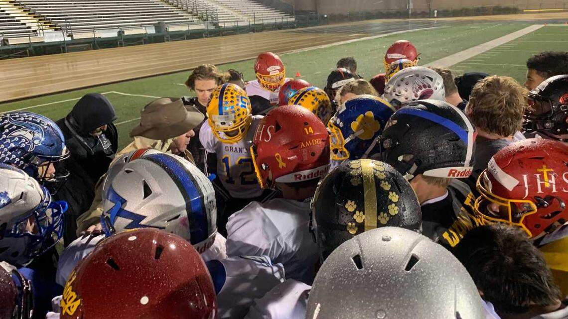 Wearing a brown hat to shield him from the rain, North Optimist All-Star coach John Volek addresses his team, including grandson Cade Brownholtz, back in red helmet, during a practice Tuesday, Jan. 15, 2019, at Sacramento State.