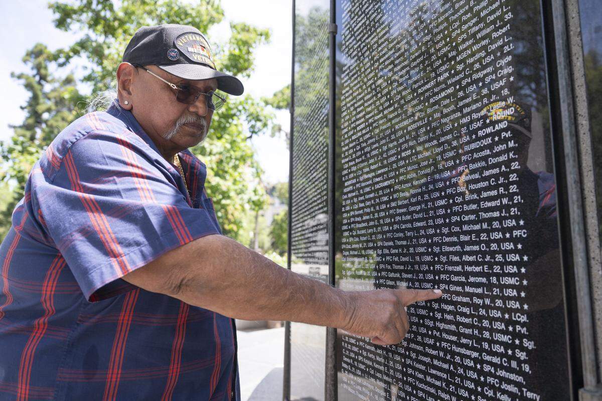 Phil Rios points out the name of his childhood friend Manuel Gines on the California Vietnam Veterans Memorial in Sacramento on Sunday, May 24, 2026. Gines was killed in the Vietnam War at age 21.