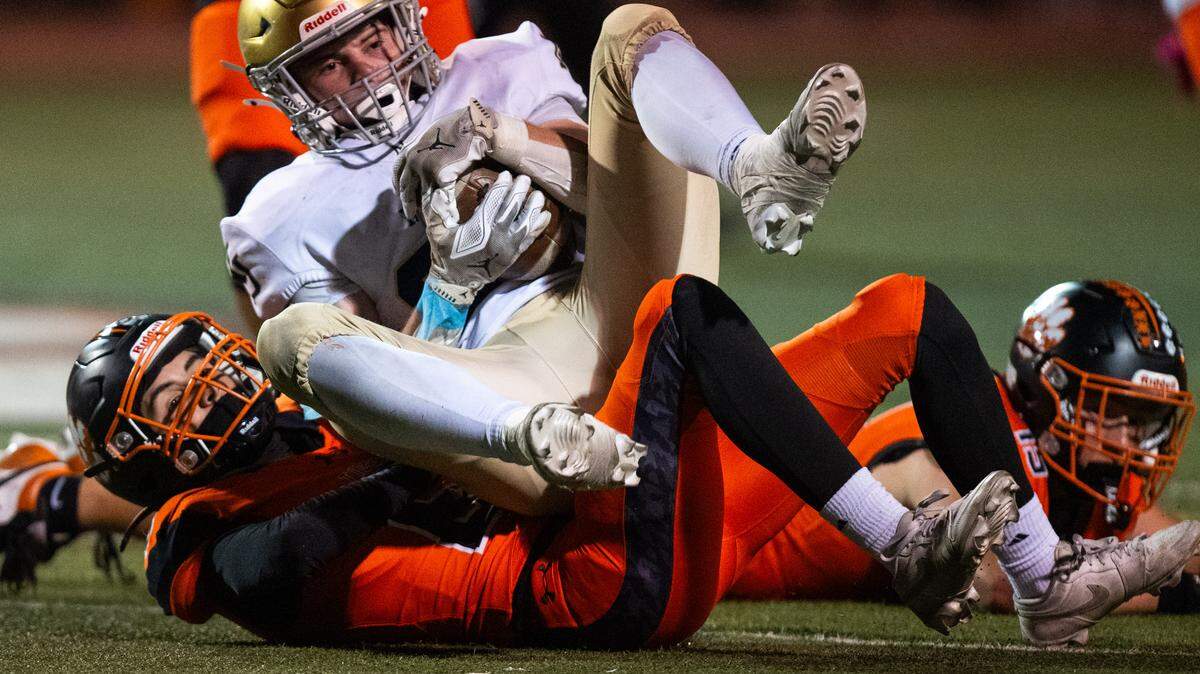 The Nevada Union Miners' Owen Hooper (23) lands on the Roseville Tigers’ Dylan Gates (6) as he catches a pass for a first down on Friday in Roseville. Hooper bounced to his feet and ran for an apparent touchdown, but the referees ruled him down. 