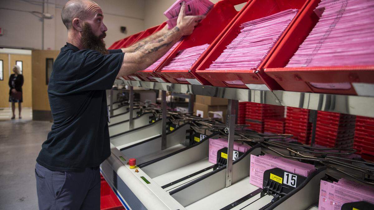 Elections assistant David Quiel works on a machine that processes vote-by-mail ballots at the Department of Voter Registration and Elections in Sacramento on Thursday, May 17, 2018.