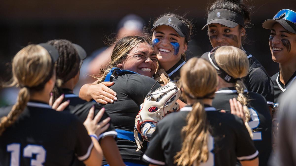 Capital Christian Cougars catcher Nani Lose-Mahina (21), left, hugs shortstop Brianna Johnson (24) after combining to end the third inning after a steal attempt from Dixon Rams baserunner Ashley Garcia (28) at the CIF Sac-Joaquin Section Division IV high school softball championship game Saturday, May 27, 2023, at Cosumnes River College.