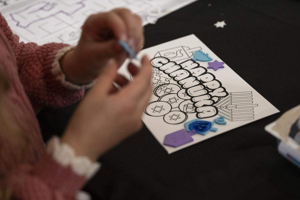 Members of the Roseville and Placer County Jewish community work on crafts during a menorah lighting on the first night of Hanukkah at the Westfield Galleria in Roseville on Sunday.