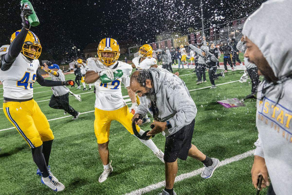 The Grant Pacers’ coach Carl Reed gets doused with water after his team’s 35-28 victory against the Pacifica Tritons to win the CIF State Division 2-AA championship at Saddleback College in Mission Viejo on Friday.