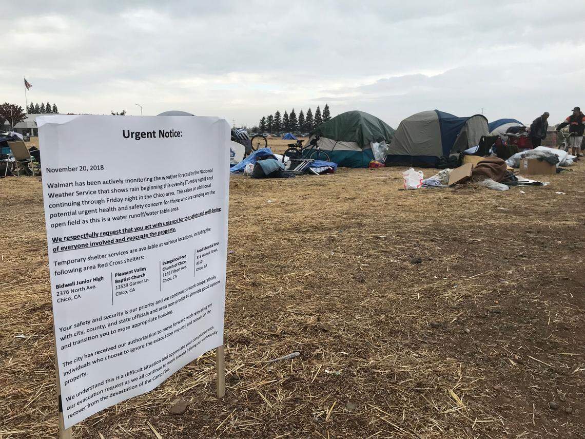 A notice posted by Walmart asks Camp Fire evacuees and others to leave the “Wallywood” tent city. About 50 tents remained in the grass lot early Wednesday.