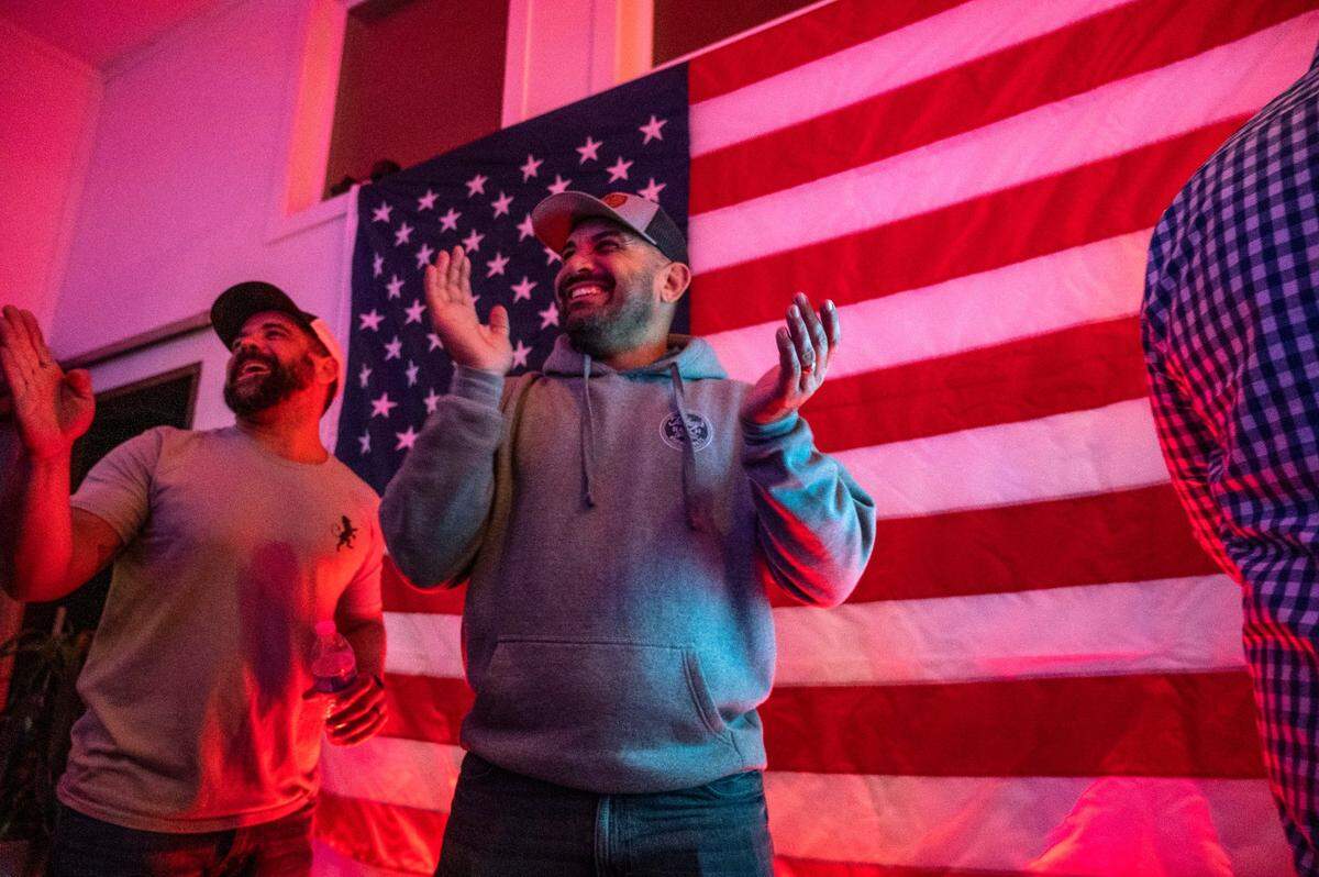 Carlos Zapata, a local restaurant owner and militia member, center, celebrates with supporters as results of the recall of Shasta County Supervisor Leonard Moty are announced on Feb. 1, at an election night party at Country Strong Fitness in Palo Cedro.