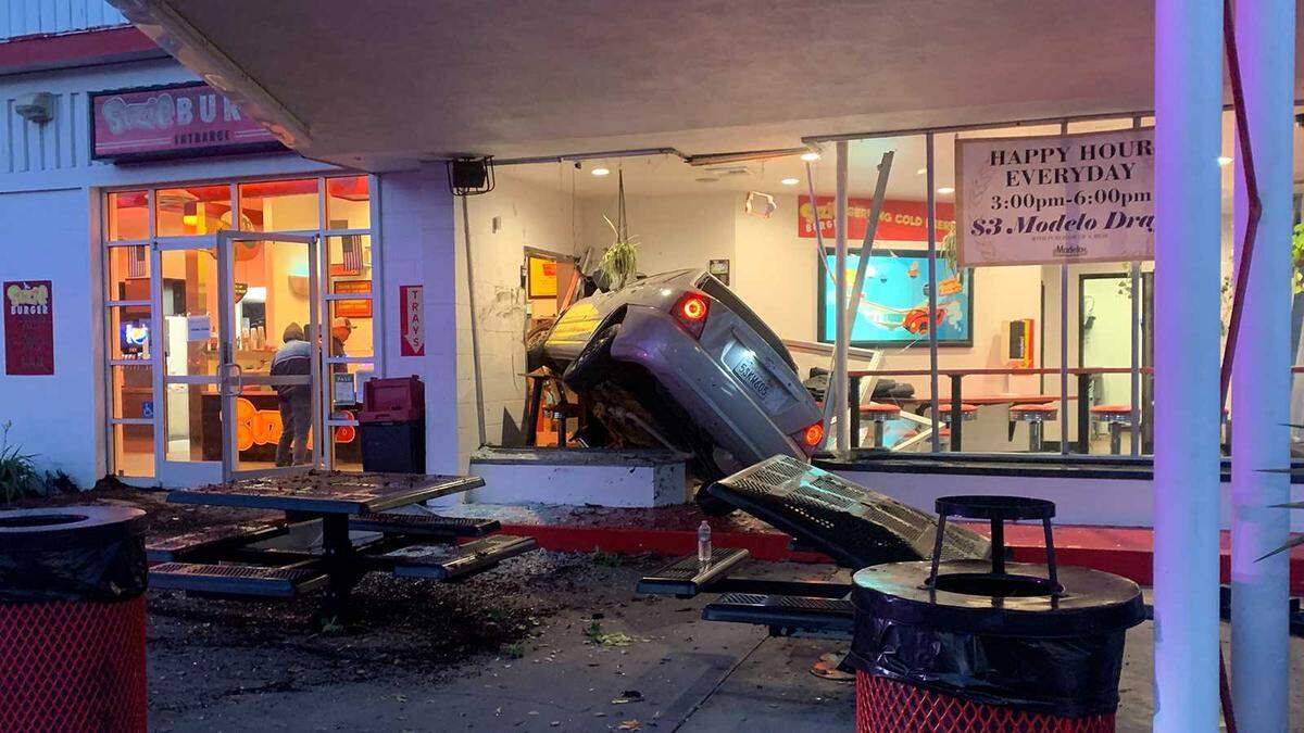 A car is seen wedged near the entrance to Suzie Burger on 29th and P streets in midtown Sacramento on Monday, Dec. 12, 2022. The driver of the vehicle was hospitalized and the cause of the crash was unknown.