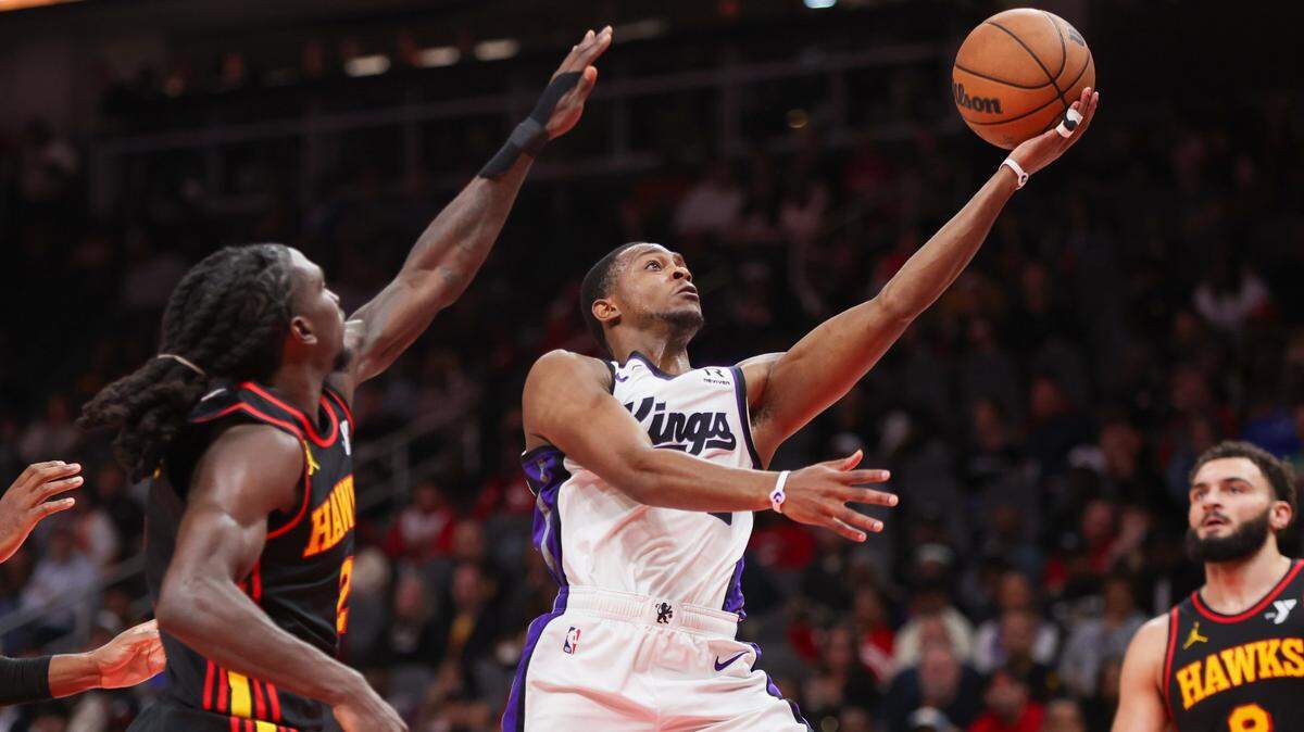 Nov 1, 2024; Atlanta, Georgia, USA; Sacramento Kings guard De'Aaron Fox (5) shoots past Atlanta Hawks guard Keaton Wallace (2) in the second quarter at State Farm Arena. Mandatory Credit: Brett Davis-Imagn Images