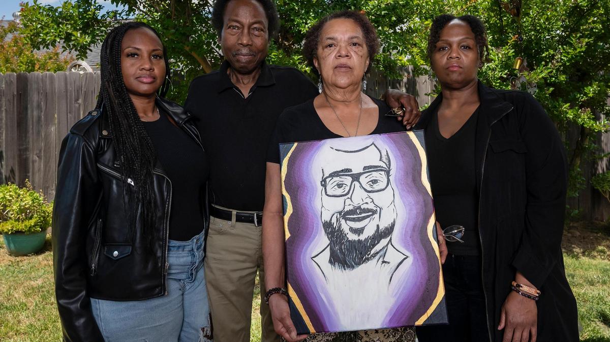 Harriett Jefferson holds a painting of her son Reginald Payne while she stands with husband Rufus, center left, and their daughters Crystal, left, and Janine, right, at their home earlier this month in Foothill Farms. Payne died in 2020 after Sacramento police restrained him in a dangerous position as he suffered a medical emergency, according to city documents.