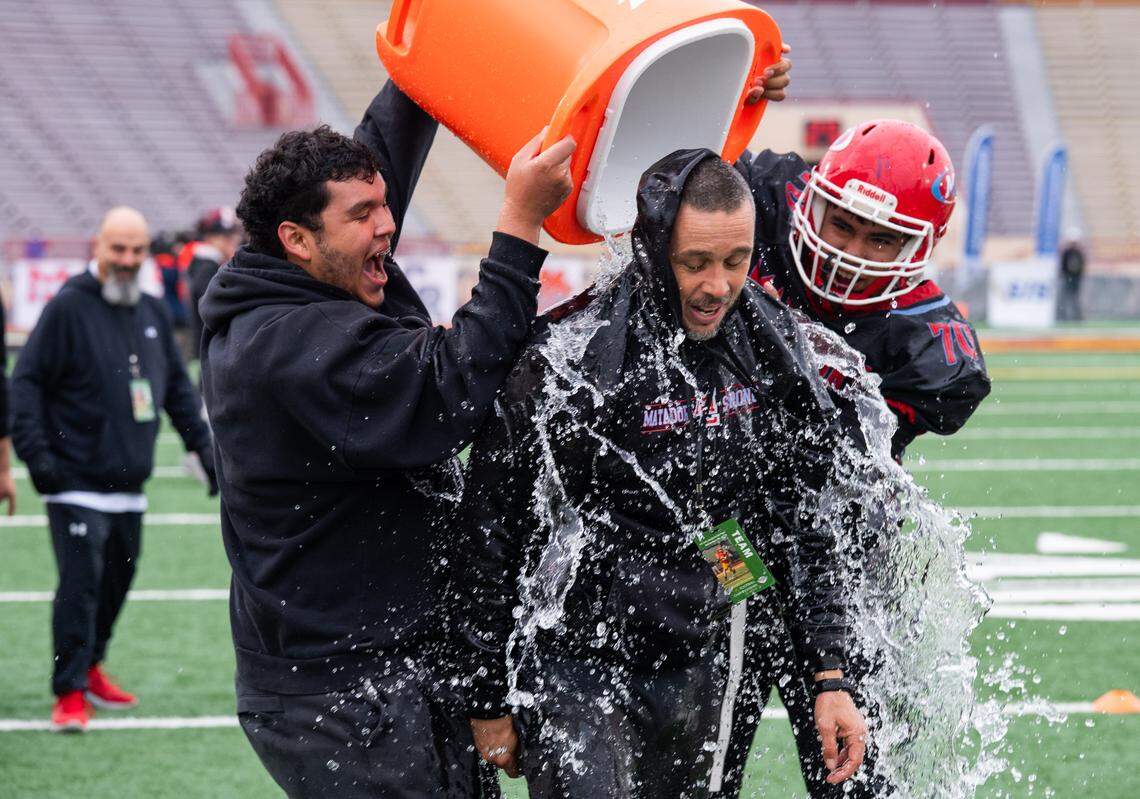 Mira Loma Matadors coach Jesse Collins is doused on the sideline as his team nears victory against the Foresthill Wildfires in the CIF Sac-Joaquin Section Division VIII championship at Hughes Stadium in Sacramento on Saturday.