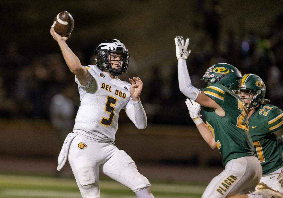 The Del Oro Golden Eagles' Nolen Sauve (5) lets a pass go as Placer Hillmen Carter Soderman (22) and Danny Sanchez-Harlow (21) rush in the second half Friday in Auburn.
