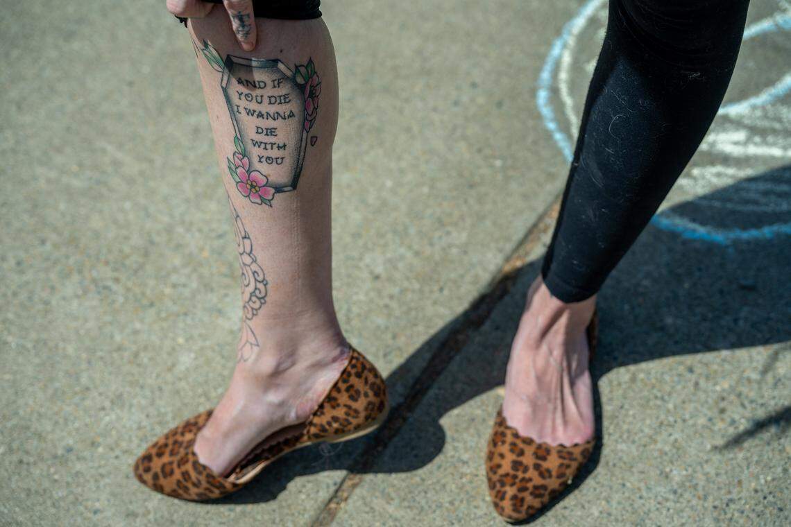 Erika Pringle shows a tattoo with lyrics from one of her brother Andrew Pringle’s favorite songs during a gathering with friends on the second anniversary of his death on April 23. Andrew was struck by a motorist while crossing Folsom Boulevard near Manlove Road in Rosemont and later died in the hospital.