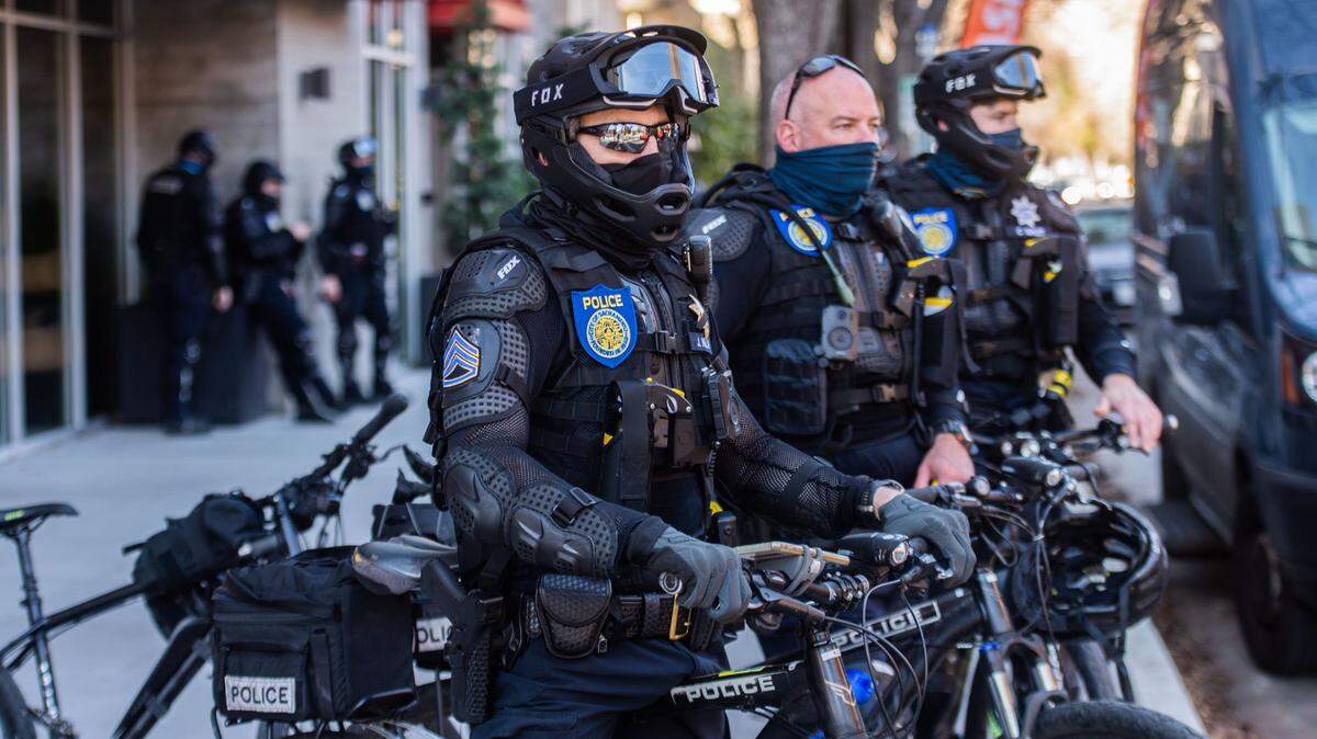 Sacramento Police officers on bikes watch an antifa group in Fremont Park on Wednesday, Jan. 20, 2021.