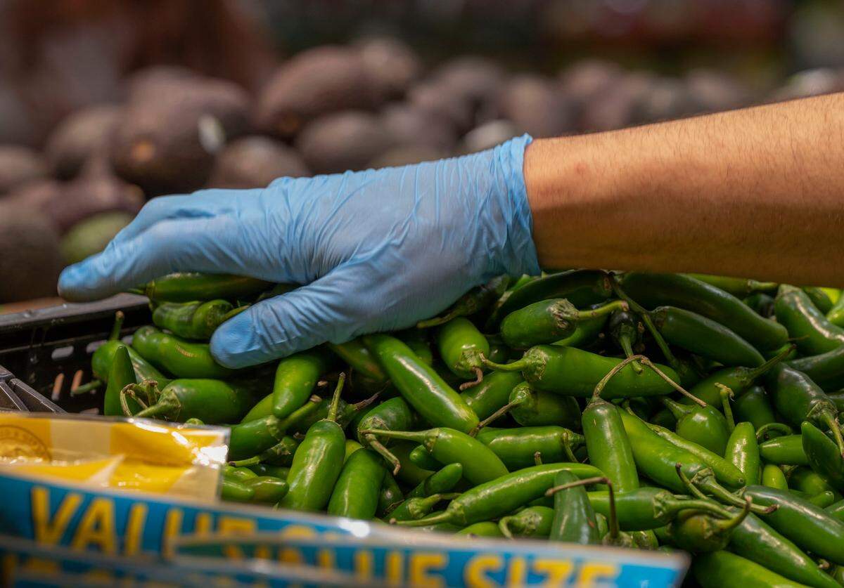 Serrano peppers are sorted during the grand opening of Rancho San Miguel Market.