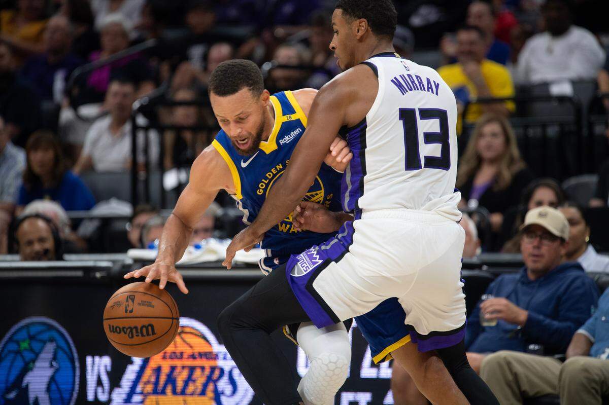 Golden State Warriors guard Stephen Curry (30) is defended by Sacramento Kings guard Keegan Murray (13) in the first half on during a preseason game Wednesday at Golden 1 Center.