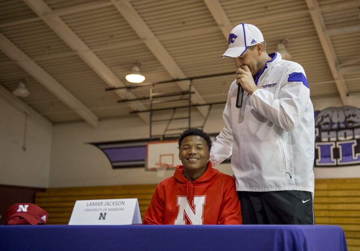 Franklin High football coach Mike Johnson, right, jokes with Lamar Jackson, who committed to Nebraska in February 2016.