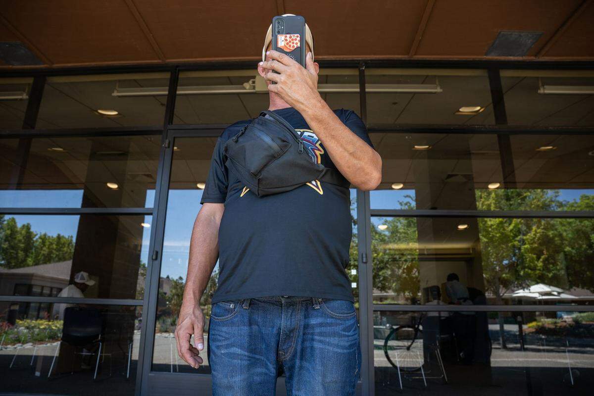 Diego de Jesús Delgado Meléndez looks at his phone while participating in activities at a local church in June. The migrants played sports and received laptops to help them learn English.