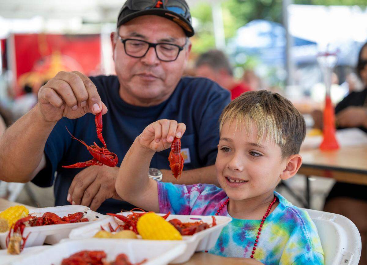 Tim Gutierrez celebrates Father’s Day as he eats crawdads with his grandson Maverick, 6, at the Isleton Crawdad Festival on Sunday.
