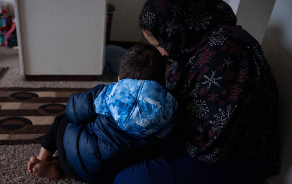 An Afghan refugee who requested her name not be used for fear of harm being done to relatives still in Afghanistan, holds her 2-year-old son, Nov. 24, at their sparsely furnished apartment in West Sacramento.