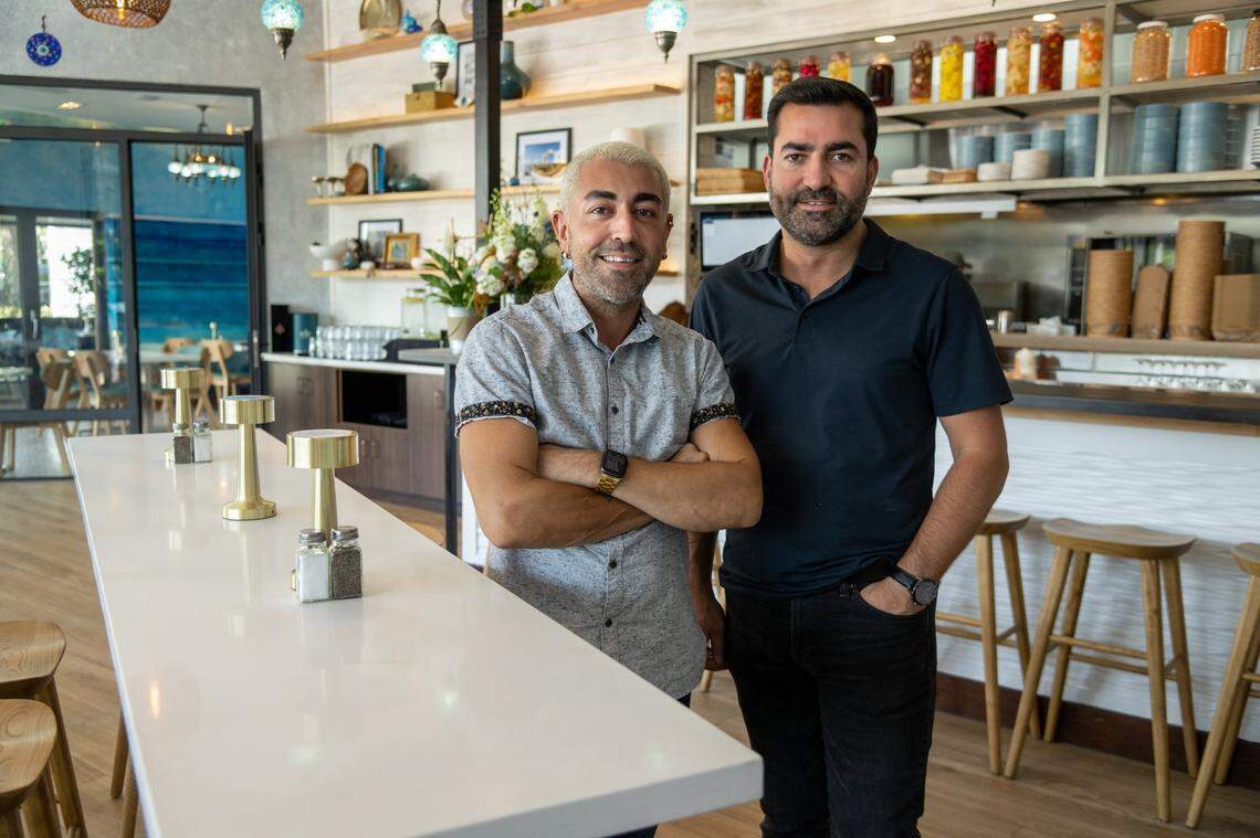 Owner Yusuf Topal, right, and general manager Demetri Gregorakis stand in the dining room at Jayna Gyro in East Sacramento earlier this month. The walls of the restaurant are painted in cool blue colors of the Mediterranean Sea to remind Topal of his days starting out as a kitchen helper on a cruise ship.