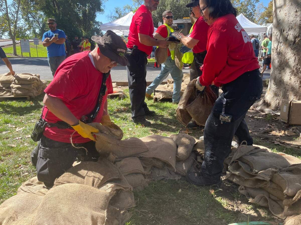 Robert Ross, left, helps his team of emergency response volunteers build a sandbag levee intended to temporarily help contain a hole in the levee. The Sacramento Fire Department oversees this volunteer unit.