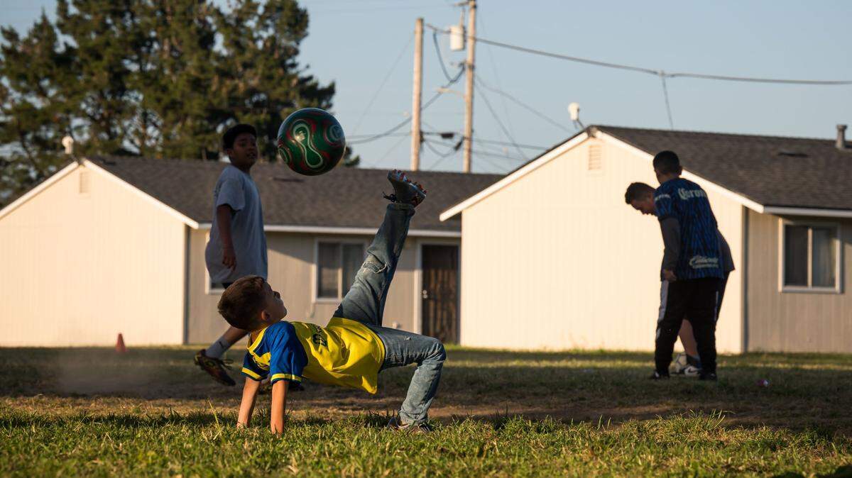 Children play soccer at a farmworker housing center outside of Watsonville in 2023. A new study finds a surge in fatty liver disease among Latino children in the United States, and the children of farmworkers are particularly at high risk because of a lack of access to healthy food.