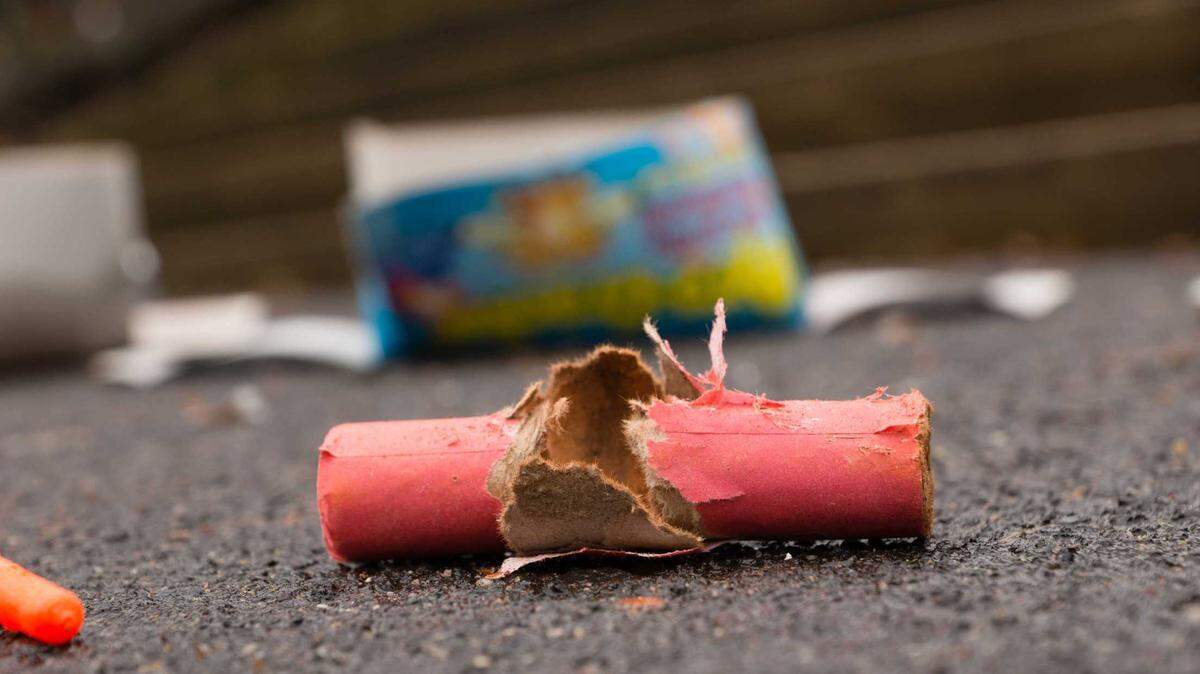 A spent firecracker laying in the street.
