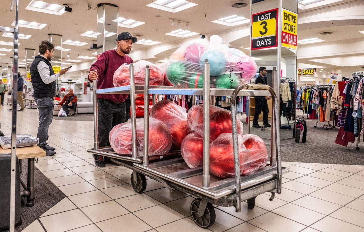 A customer maneuvers a cart with decorative spheres purchased at the Downtown Commons Macy’s store in Sacramento on Thursday. In addition to its traditional merchandise, the store is selling parts of displays and decorative elements. 