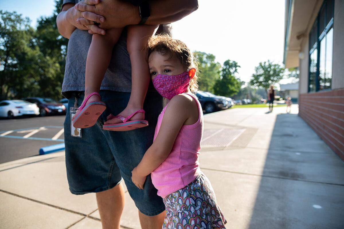 Katherine Cameron, 5, hugs her father, Brian, as she waits to attend her first day of school at Rescue Elementary School on Monday, Aug 17, 2020. The school is able to open for in-class instruction because El Dorado County is not on the state’s coronavirus watchlist.