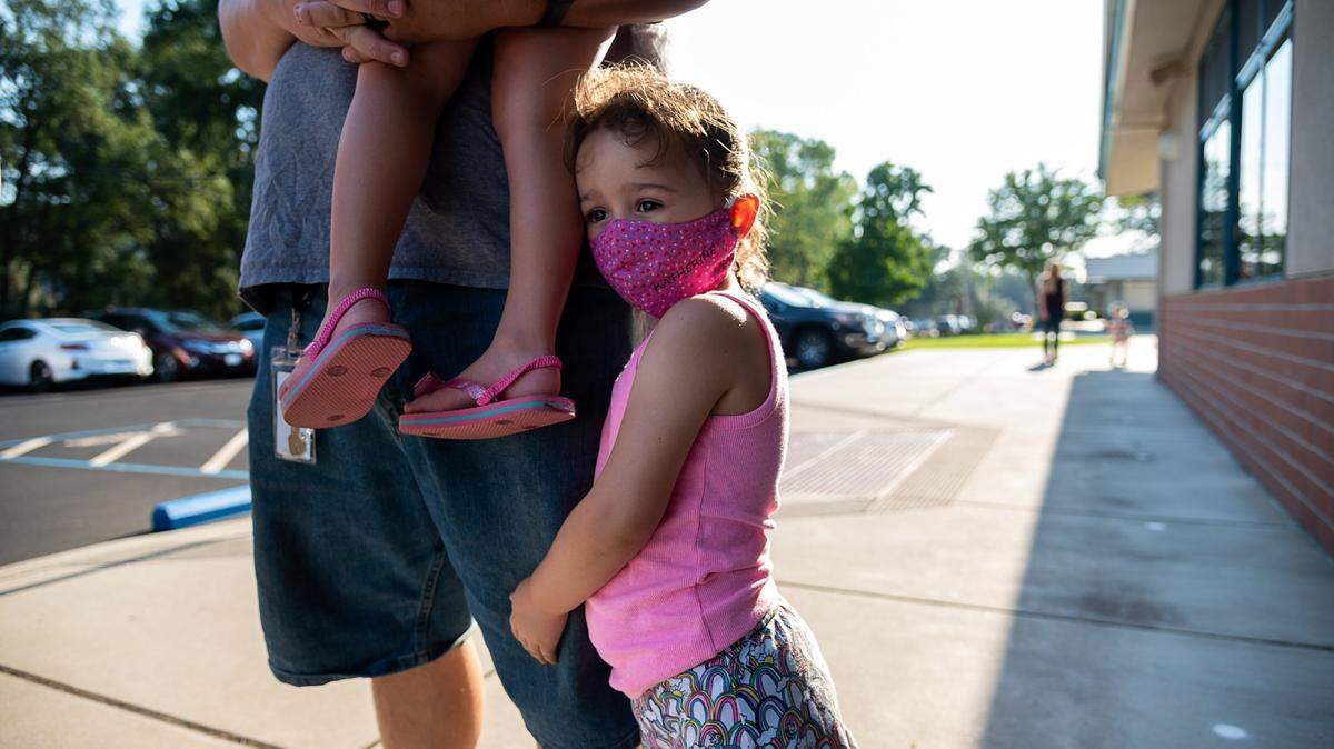 Katherine Cameron, 5, hugs her father, Brian, as she waits to attend her first day of school at Rescue Elementary School on Aug 17, 2020, in El Dorado County.