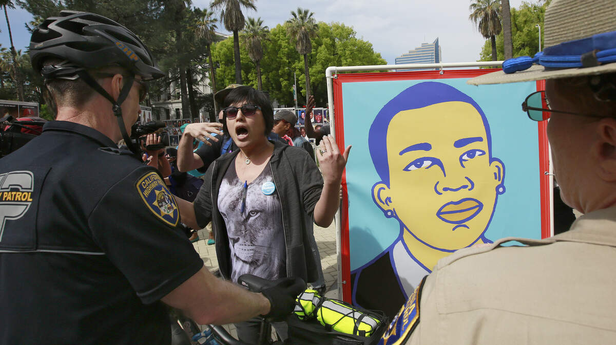 California Highway Patrol officers block protesters as they march to a crime victims' rally Monday, April 9, 2018, at the Capitol in Sacramento, Calif. The protesters are calling for charges to be filed against two Sacramento police officers who shot and killed Stephon Clark.