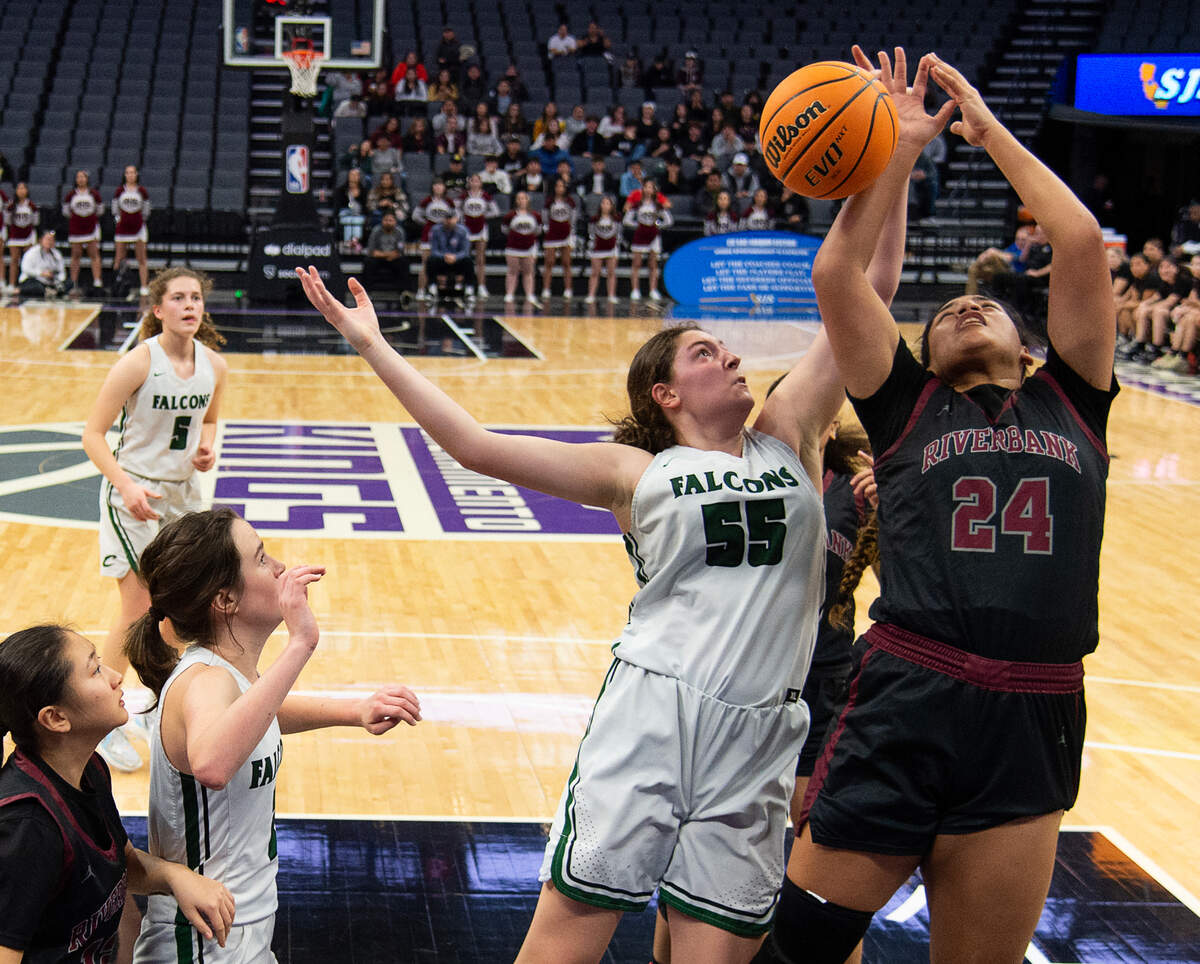 The Colfax Falcons’ Juliette James (55) battles for a rebound against the Riverbank Bruins’ Rayne Tago (24) during the CIF Sac-Joaquin Section Division IV high school girls basketball championship game Friday.